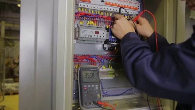 Electrician working with circuit breaker at a industrial factory. HD.
