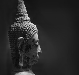 Traditional Buddha head against a black background with copy space. 