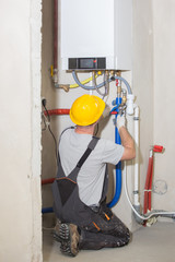 Technician servicing heating boile,  plumber
