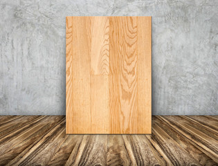Blank wood plain frame leaning at concrete wall on wooden floor
