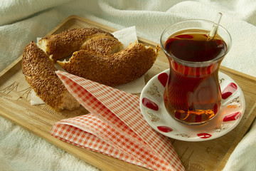 Morning turkish tea in traditional glass with bagel on the tray,
