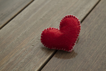 Red textile heart on wood background,  love concept