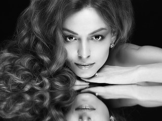 beautiful woman with mirror reflection. beauty model girl with make-up and curly hair