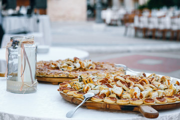 Round boards with salty pastry stand on white table outside