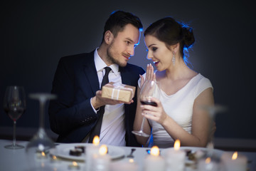 Man handing over small present to her woman