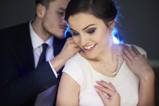 Loving man putting necklace on girlfriend