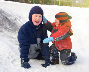 Fototapeta na wymiar Happy children playing on a little snowy hill.