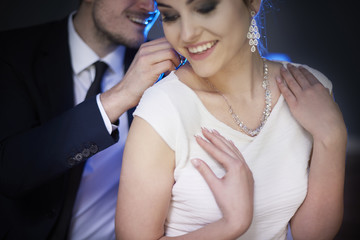 Smiling man giving woman elegant necklace .