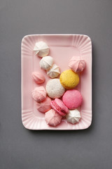 Macarons and meringues on the pink plate. Top view