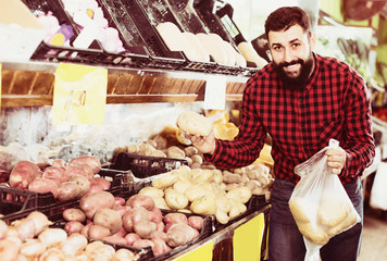 man seller showing potatoes