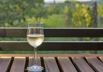Glass of wine on wooden table with picturesque view