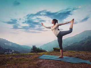 Fototapeta na wymiar Woman doing yoga asana Natarajasana outdoors on sunset