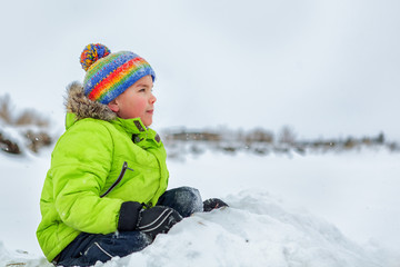 portrait of happy ruddy kid in winter clothes. outdoor