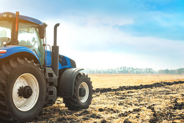 Obraz premium Modern tractor working in a field.
