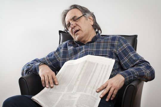 Sitting senior man reading newspaper