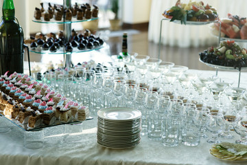 Dinner table served with cocktails and dishes with sweets