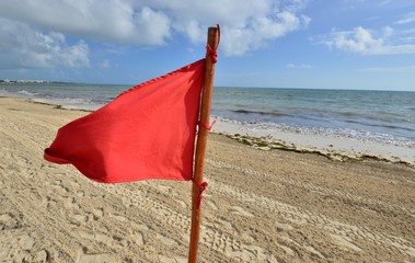 A red warning flag on the beach in the Caribbean