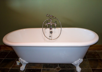 White bath tub against olive green background