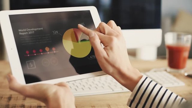 Business woman reviewing financial data on digital tablet