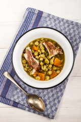 pea soup with smoked pork and carrot in an enamel bowl