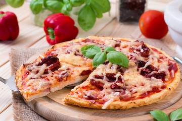 delicious pizza, vegetables and spices on wooden table