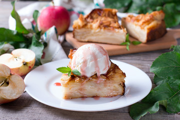 Closeup of a slice of apple pie with a scoop of ice cream on a plate