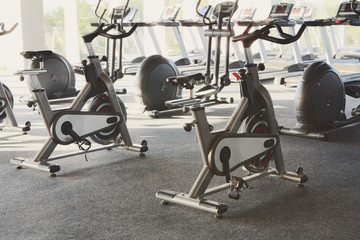 Fototapeta na wymiar Modern gym interior with equipment, fitness exercise bikes