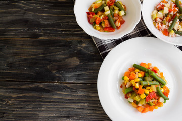 Vegetable salad in a white plate on a wooden background. Dietary dish.