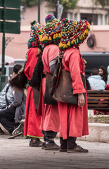 Drei Männer  in roter Kleidung mit großen verzierten Hüten  als Wasserträger in Marrakesch...