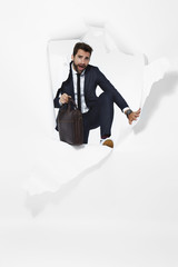 Businessman escaping from torn paper, portrait