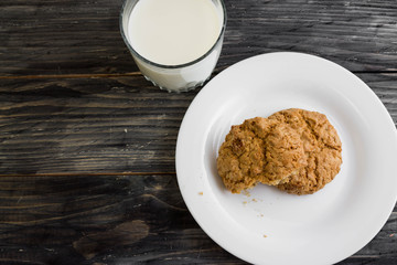 Oatmeal cookies with milk on a wooden table in rustic style