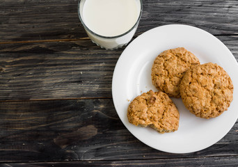 Oatmeal cookies with milk on a wooden table in rustic style