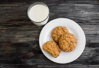 Oatmeal cookies with milk on a wooden table in rustic style