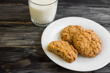 Oatmeal cookies with milk on a wooden table in rustic style