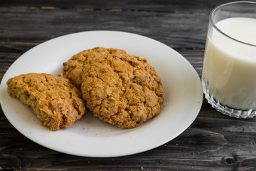 Oatmeal cookies with milk on a wooden table in rustic style