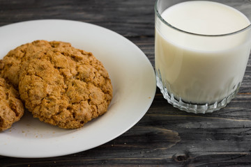 Oatmeal cookies with milk on a wooden table in rustic style