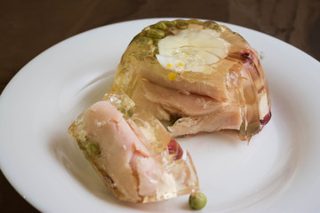 Aspic with ham and vegetables on a white plate