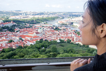 Fototapeta na wymiar Woman watches cityscape of Prague from outlook tower