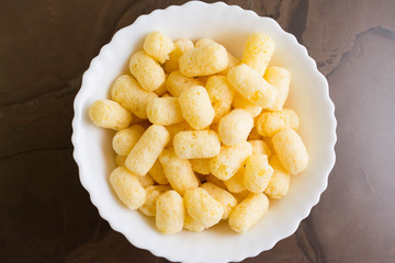 Sweet corn sticks in a white bowl. Tasty dessert.