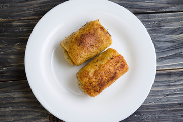 Fried pancakes with meat on a white plate