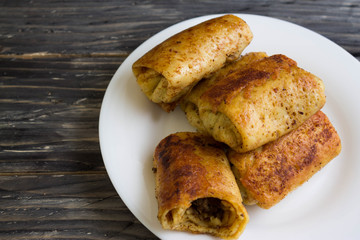 Fried pancakes with meat on a white plate