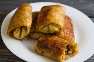 Fried pancakes with meat on a white plate