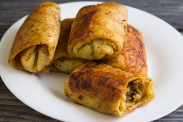 Fried pancakes with meat on a white plate