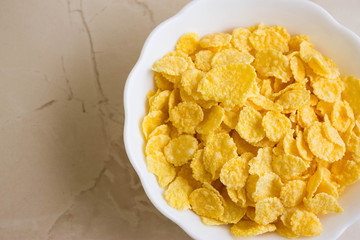 Cornflakes in a white bowl. A hearty and delicious breakfast.