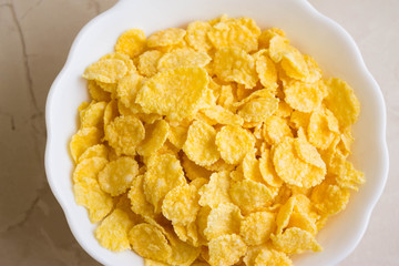 Cornflakes in a white bowl. A hearty and delicious breakfast.