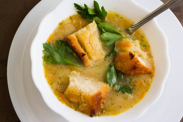Pea soup with croutons in a white bowl on a marble table
