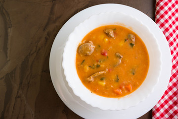 Tomato soup with chicken giblets in a white bowl
