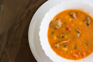 Tomato soup with chicken giblets in a white bowl