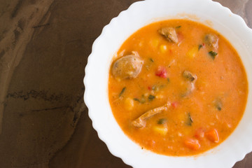 Tomato soup with chicken giblets in a white bowl