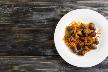 Fried chicken hearts with vegetables on a white plate